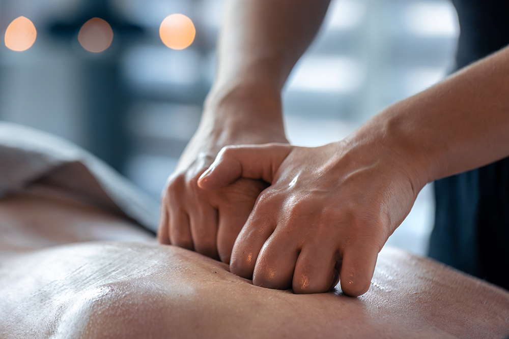 Therapist using knuckle pressure during a Tulsa deep tissue massage as part of a medical massage of Tulsa treatment session.